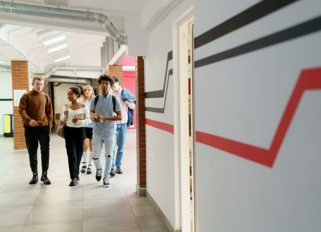 Estudantes caminham e conversam animados numa escola de ensino alternativo em Portugal.