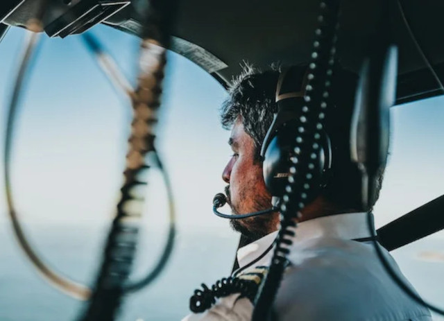 Piloto de avião dentro da cabine a pilotar.