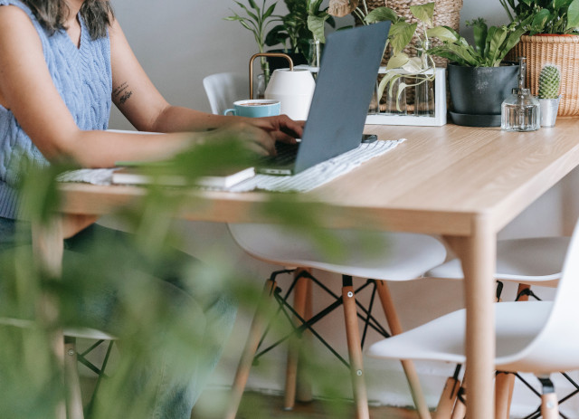 Mulher a pesquisar no computador como procurar trabalho online sentada a uma mesa.