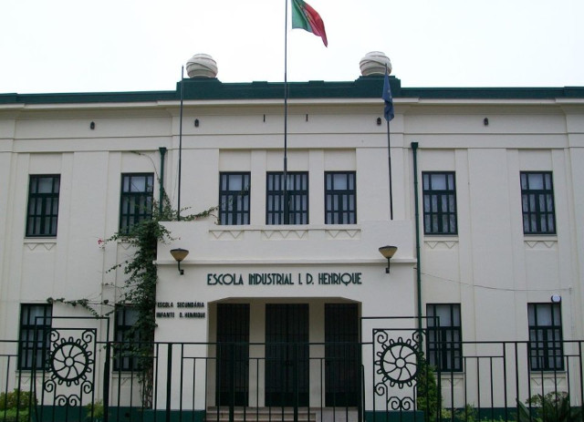 Fachada de entrada branca, com portões de ferro verde, da Escola do Infante D. Henrique no Porto.