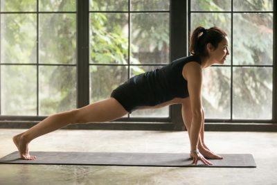 jovem mulher faz aula de yoga comunitário