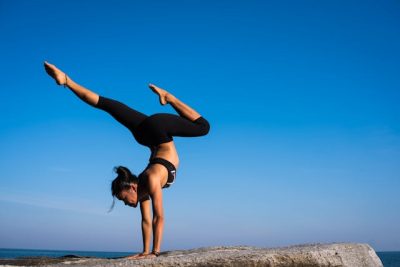 mulher faz posição de yoga no topo de montanha
