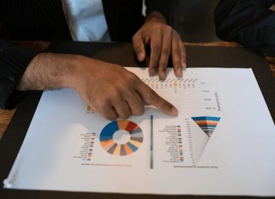 gerente de programas aponta para folha de acompanhamento de metas