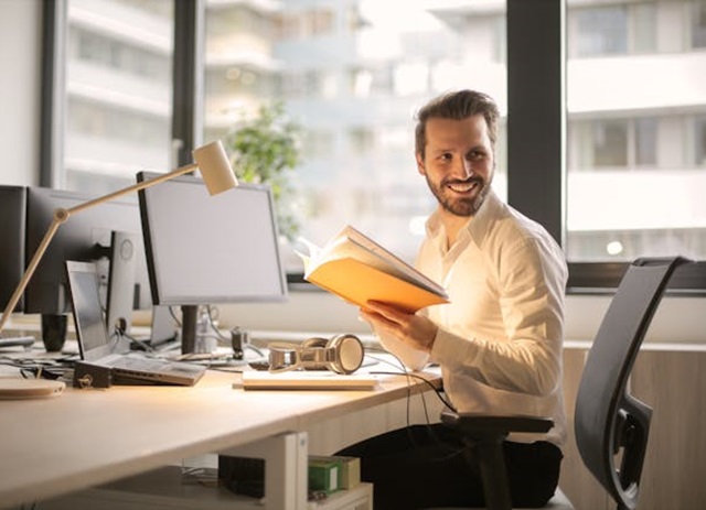 gerente de escritório - office manager trabalha na secretária com computador e cadernos