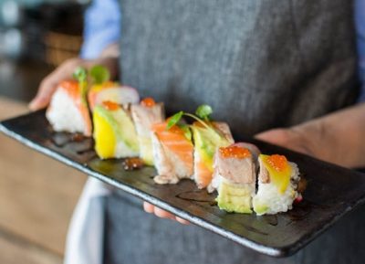sushiman serve travessa com várias peças de sushi