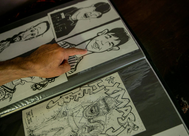 Mão de homem aponta para desenho de rapaz a preto e branco mostrando para que serve um portfolio.